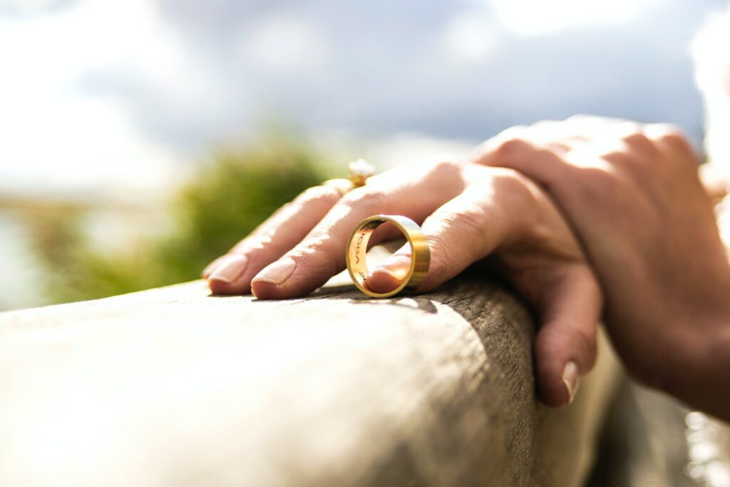 person holding gold wedding band symbolizing divorce